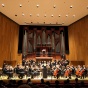 Orchestra performing on the stage at Slee Hall. 